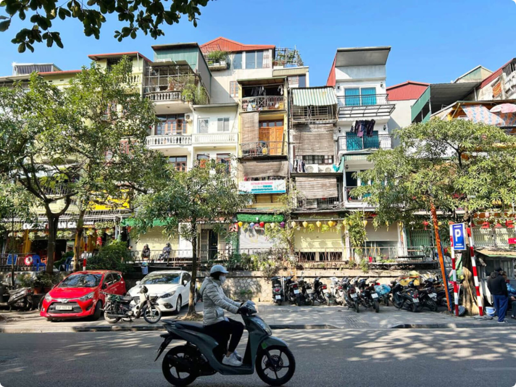 Здания и человек на мопеде