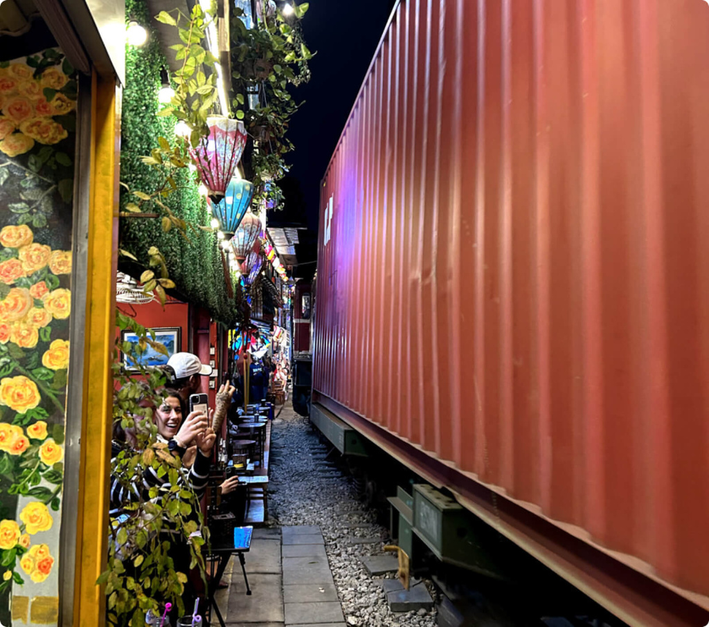 Поезд проезжающий вдоль кафе